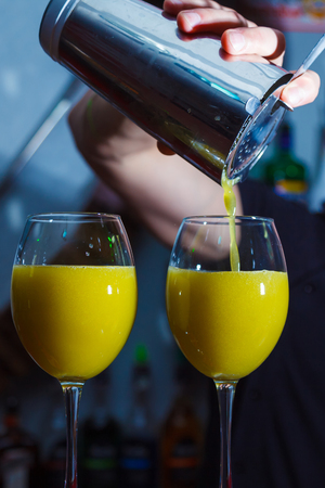 preparation of a bright yellow cocktail on the barの写真素材