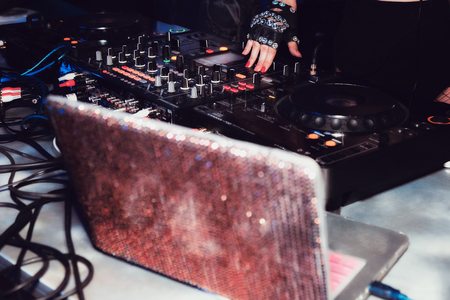 DJ mixes tracks at a party. DJ control panel