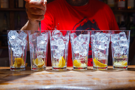 cubes of ice in glass with slice of lemon on bar. cocktailの写真素材