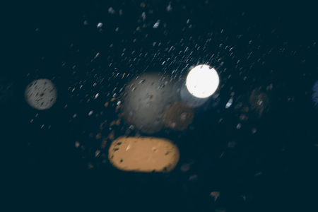 beautiful background of night lights, bokeh through wet glassの写真素材