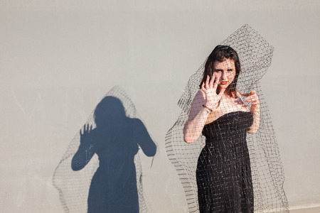 Attractive girl in futuristic clothes on the background of concrete structuresの写真素材