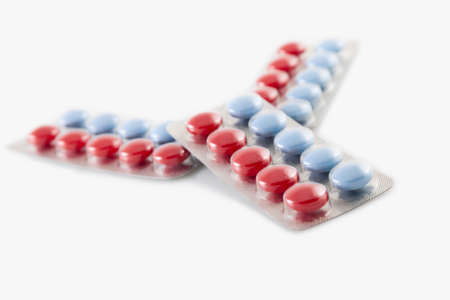 packaging of pills blue and red pills on white backgroundの写真素材