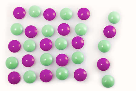 group of purple and green pills on white background