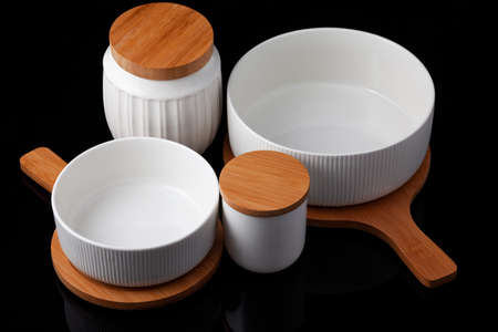 a set of porcelain and wooden utensils, on a black background.