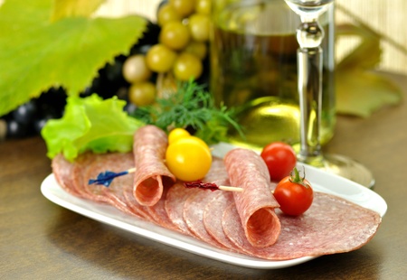 Sliced Salami with tomatoes and salad leaves の写真素材