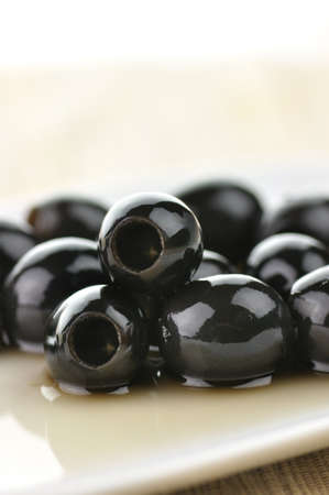 big black olives in a white plate, close upの写真素材