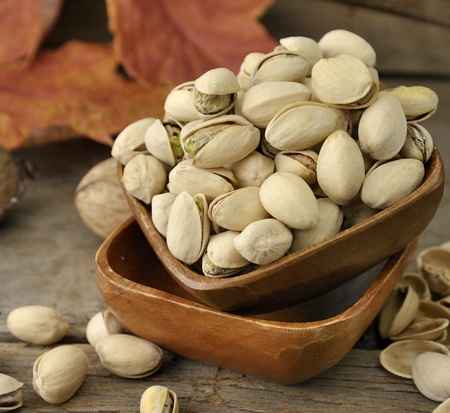 Cracked and Dried Pistachio Nuts In A Wooden Bowl の写真素材