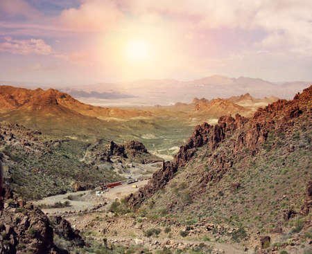 Mountain landscape with a gold mining area in a valley at sunset.の写真素材