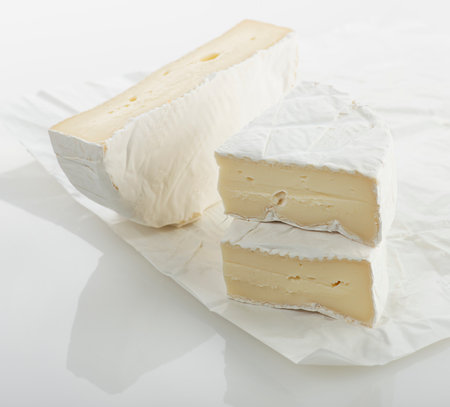 Wedges of french brie cheese on a paper packagingの写真素材