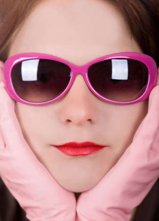 Portrait shot of a young woman wearing pink sunglassesの写真素材