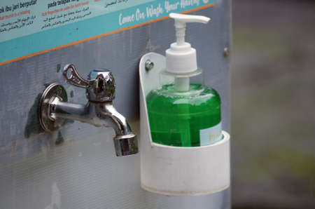 Close up of a faucet with hand soap beside itのeditorial素材