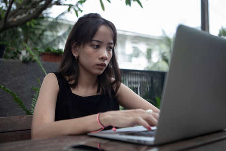 Portrait of a serious businesswoman using laptop in the home garden