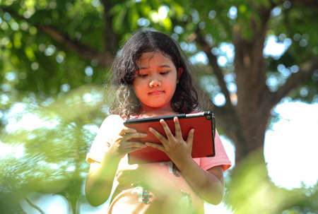 Cute young girl using a digital tabletの写真素材
