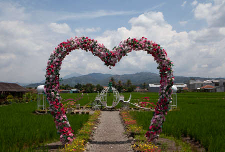 Bandung, Indonesia-September 26, 2021: a place in the middle of the rice fields with a door symbolizing love from flowersのeditorial素材