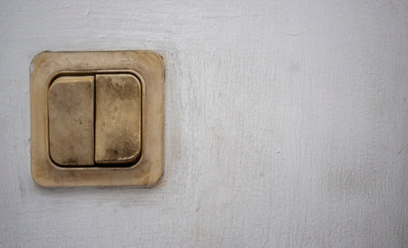 Old light switch on white wall with copy space for textの写真素材