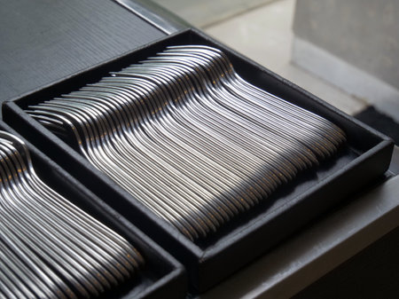 closeup of stainless steel cutlery in black box on shelfの写真素材