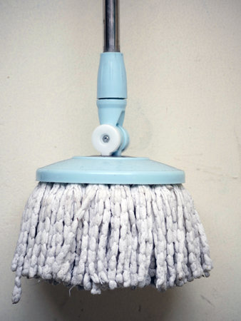 Cleaning mop on white wall background. Cleaning service concept.