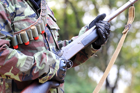 A man in soldier suit with rifle and bullets