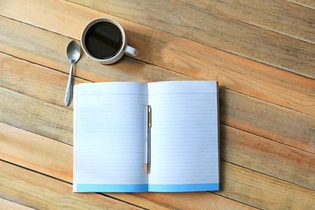 Black coffee and book on wooden plateの写真素材