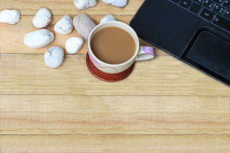 Brown coffee and labtop with white stone on wood plateの写真素材