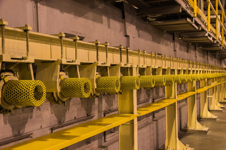 Yellow guard of steel roller shaft for safety in factory,yellow light backgroundの写真素材