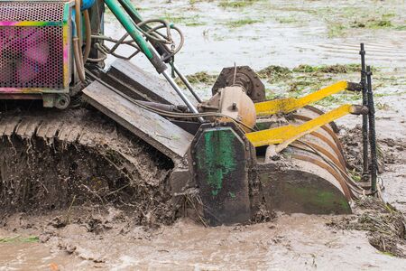 agriculture farmland,tractor with plough ploughing a soil field