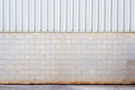 Factory wall made of metal sheet and stone block,wall plant creem colorの写真素材