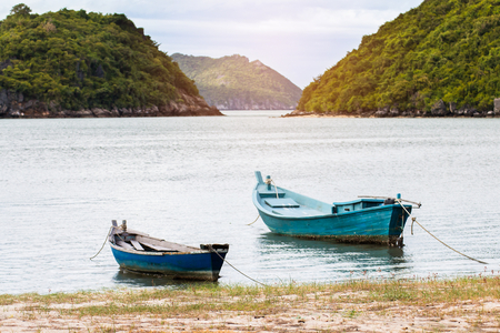 Small fishing boats made from wood on the beach,Fishing boats in the sea in Thailandの写真素材