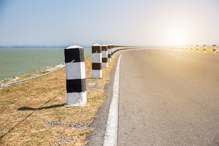 Milestones,black and white milestones with green grass roadside,lake roadside in background,concept for next step.go on
の写真素材