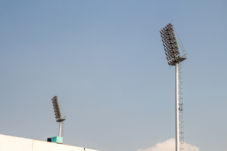 giant spotlights are in the stadium to the high pole with sky backgroundの写真素材