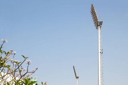 giant spotlights are in the stadium to the high pole with sky background