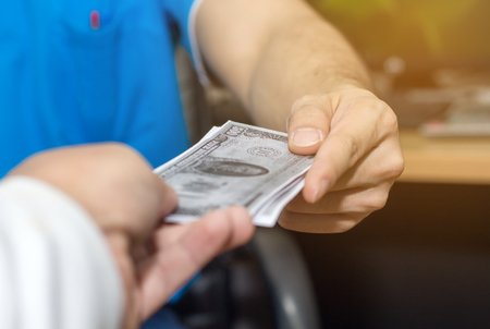 Person hand accept money bribe from construction project,corruption concept
の写真素材