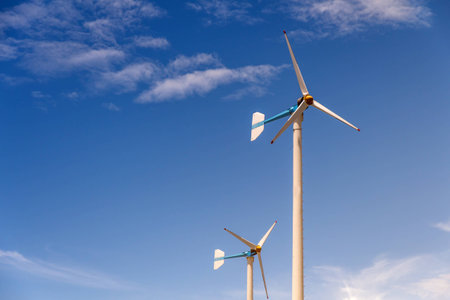 Wind turbine generating electricity on blue sky with clounds,Windmills for electric power ecology...