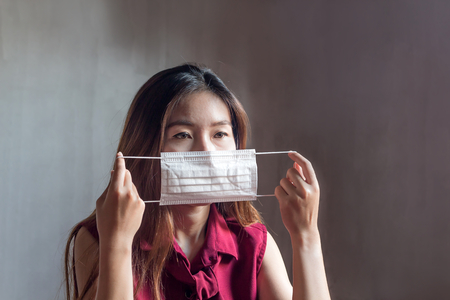 Young Asian Chinese Thai woman wearing respiratory mask to protect the dust and the smoke in the pollution air,healthcare conceptの写真素材
