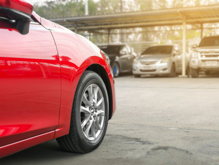 new red car in the parked with many cars on parking lot