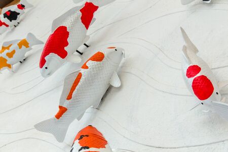 Carps fish or koi fish statue on cement wall for decorate, stucco handcraft of koi carp fish on the wallの写真素材
