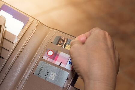 Cropped shot view of female hands picking credit cards from her wallet