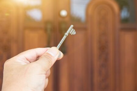 Key on hand of people open the door to inside outside door open putting into front doorの写真素材