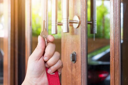 Key on hand of people open the door to inside outside door open putting into front door
