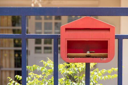 Mailbox in front of the house and gate with sunlight and beautiful natural background,The letter box looks old and damageの写真素材