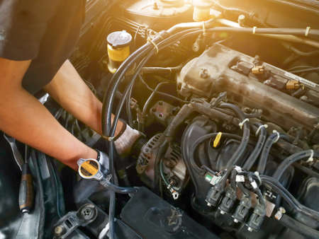 Auto mechanic with tool working check and fixed an old car engine at service station,change and...