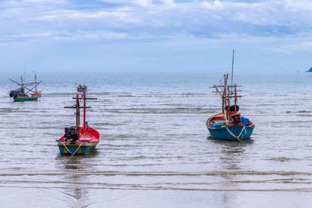 Small fishing boats made from wood on the beach,Fishing boats in the sea in Thailandの写真素材
