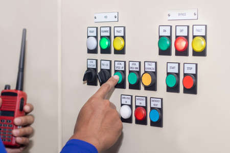 Hand of people key switch select mode in electrical control panel contains switch buttons for...