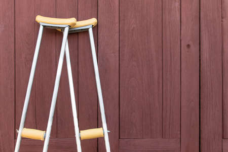 Empty walking stick or staff cane for patient or senior or elderly people on wooden background,healthy medical conceptの写真素材