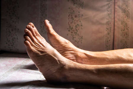 Put of young hand on the leg of the elderly person to check for symptoms of illness,health care...