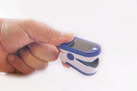 Male hands using modern pulse oximeter,Unrecognizable man using modern pulse oximeter,male patient putting clip-like small device for blood oxygen, saturation measuring and coronavirusの写真素材