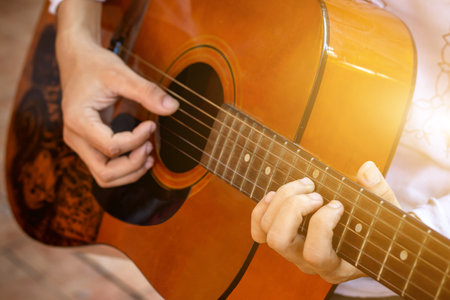 close up hand of people playing guitar,man playing acoustic guitar. Selective focus
