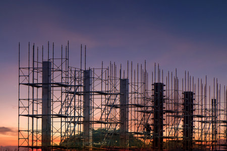 Scaffolding pipe clamp and parts,construction site with scaffold and building strength to scaffold clamps in used close up on construction site with sunset background,scaffolding for construction factoryの写真素材