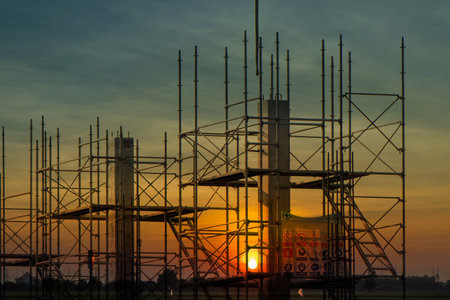 Scaffolding pipe clamp and parts,construction site with scaffold and building strength to scaffold clamps in used on construction site with sunset background,scaffolding for construction factoryの写真素材