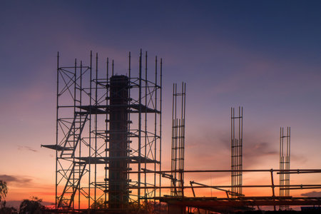 Scaffolding pipe clamp and parts,construction site with scaffold and building strength to scaffold clamps in used on construction site with sunset background,scaffolding for construction factoryの写真素材
